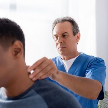 Il medico conduce un esame diagnostico di un paziente con dolore al collo